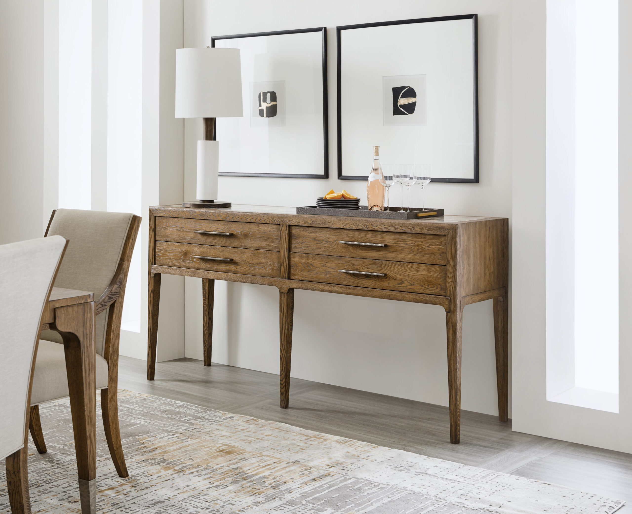 Hooker Furniture Chapman Sideboard featuring white oak veneers, a silver travertine stone top, four drawers, pewter hardware, and a Sorrel finish. A refined, casual design perfect for modern, smaller-scaled spaces.