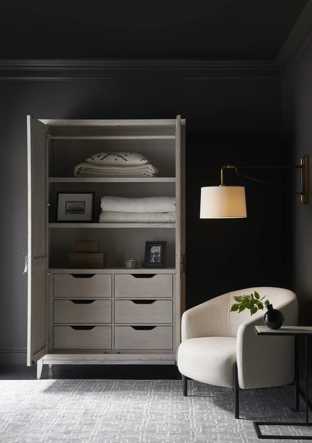 The Coalesce Wardrobe offers elegant storage with regal, linear detailing. It includes two interior shelves and six tray drawers, providing versatile and stylish space for wardrobe essentials.