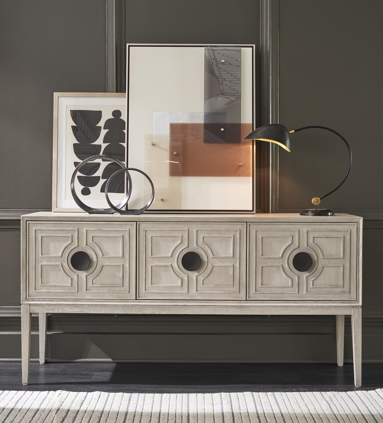 Madden Sideboard in Rolling Fog finish features intricate carvings, two adjustable shelves, pull-out trays, and a felt-lined silverware drawer.