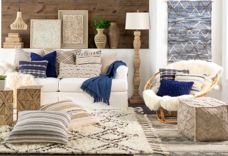 Cozy living room with a variety of decorative pillows in neutral and blue tones on a white sofa and chair.